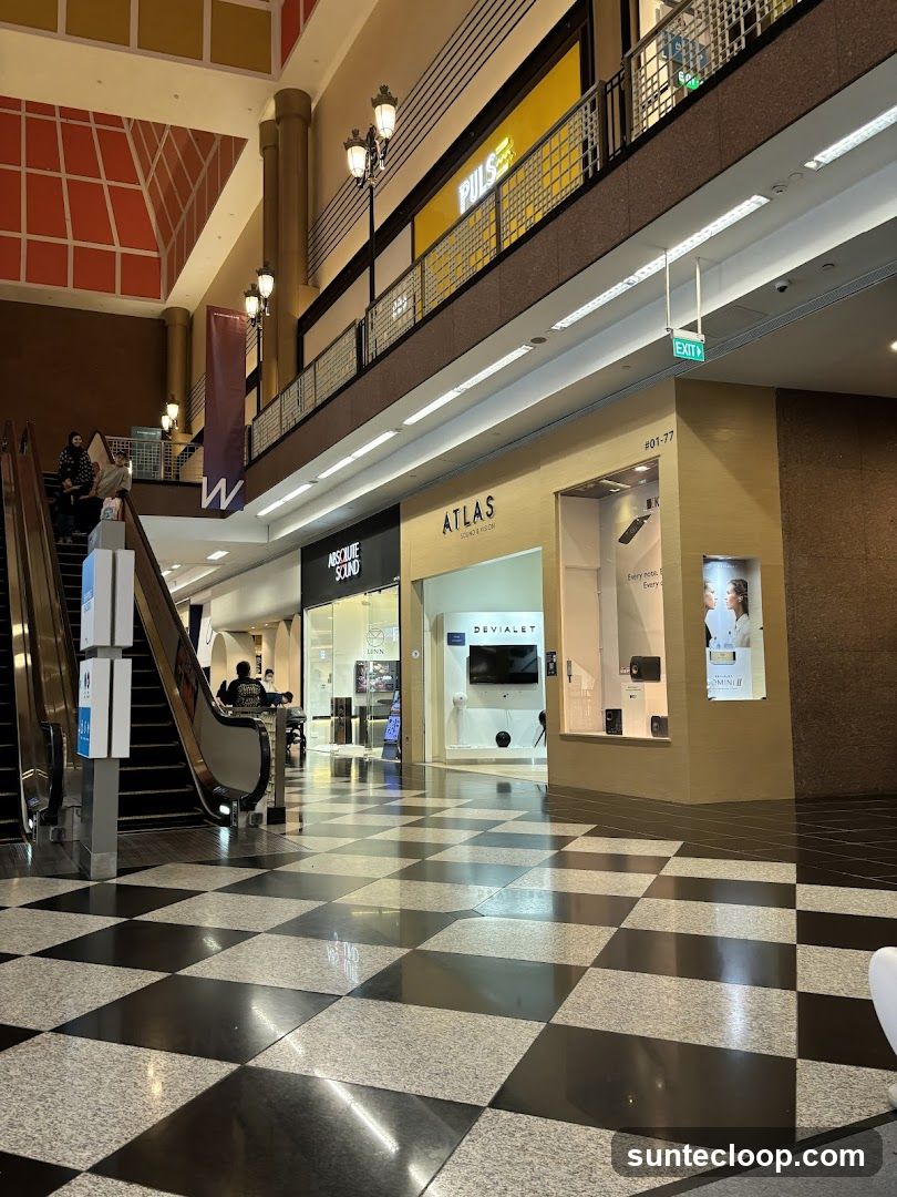 Shopping mall interior with escalators and storefronts