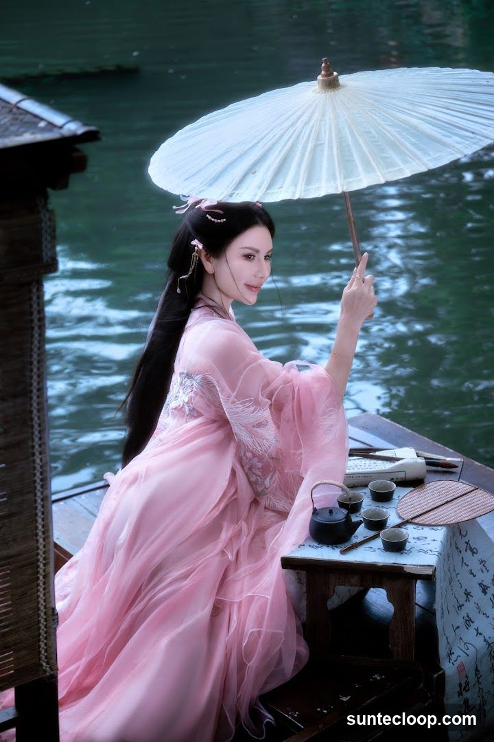 Woman in Traditional Chinese Attire with Tea Set