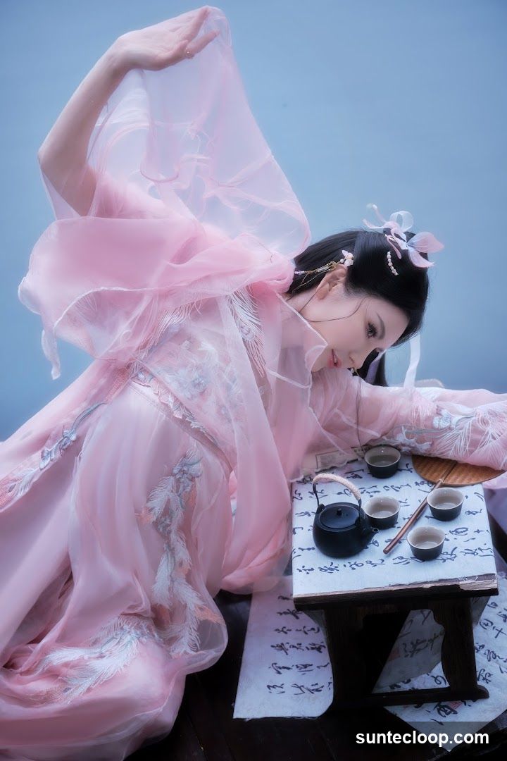 Woman in Traditional Chinese Attire with Tea Set