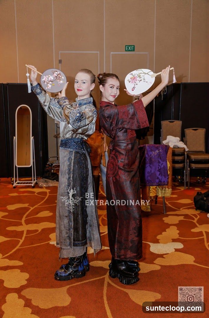 Two women in traditional Chinese attire holding fans
