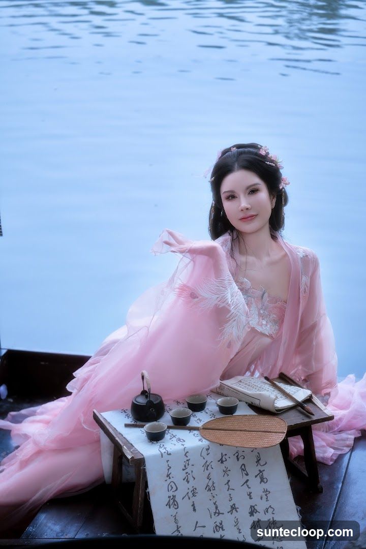 Woman in Traditional Chinese Attire with Tea Set
