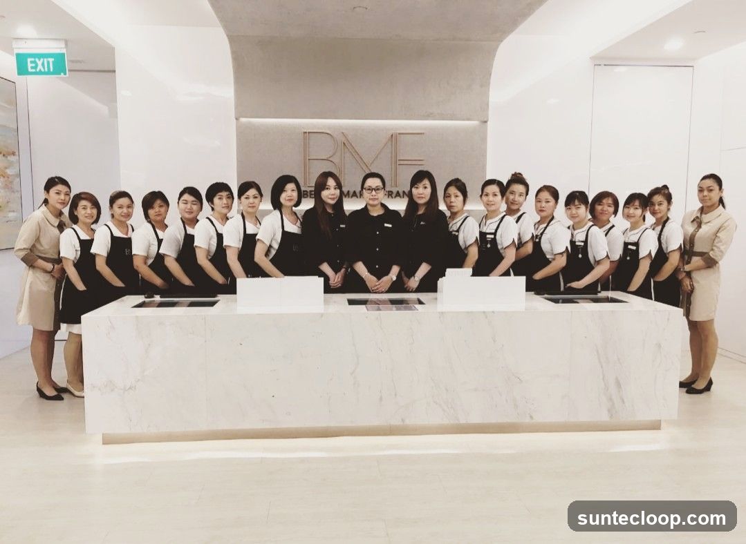 Staff Posing in Front of Business Logo