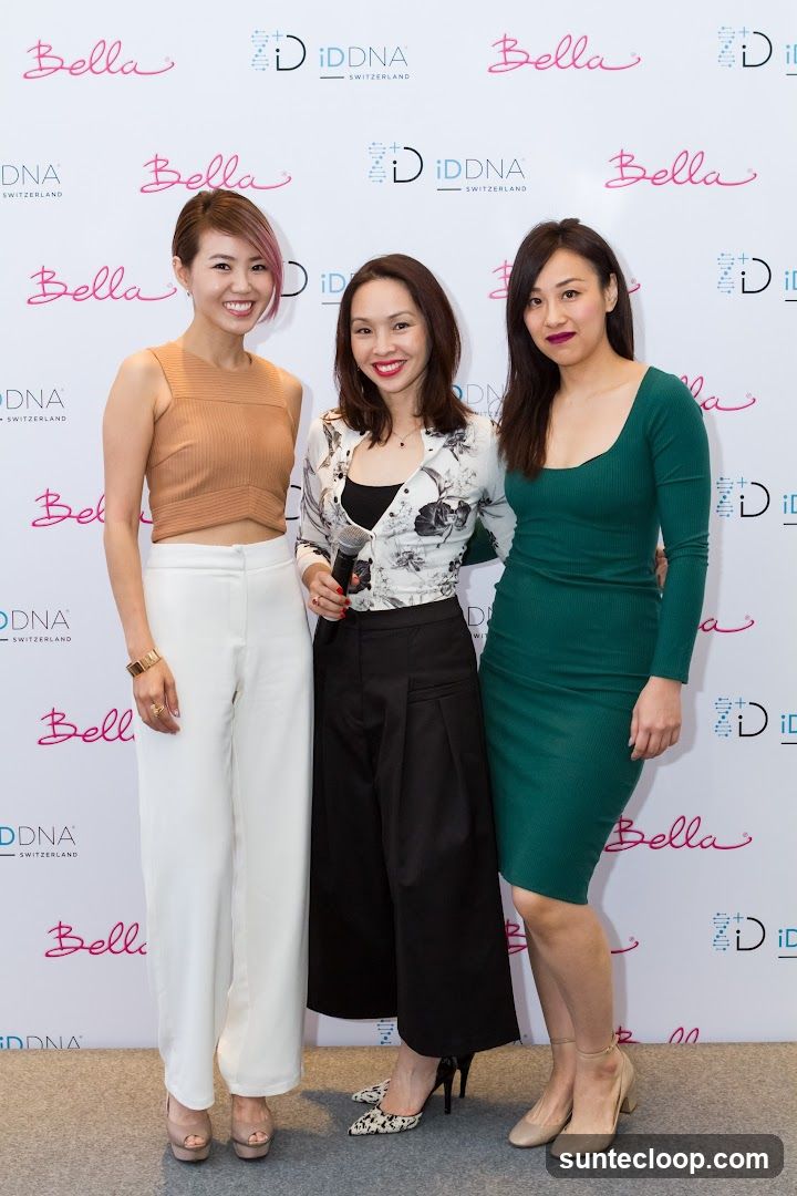 Three women posing in front of a branded backdrop