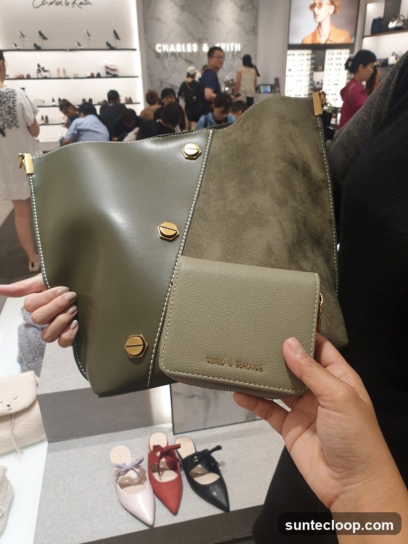 Hand holding a wallet and bag in a store