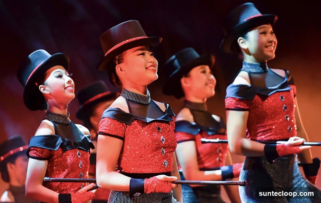 Performers in sequined costumes and top hats