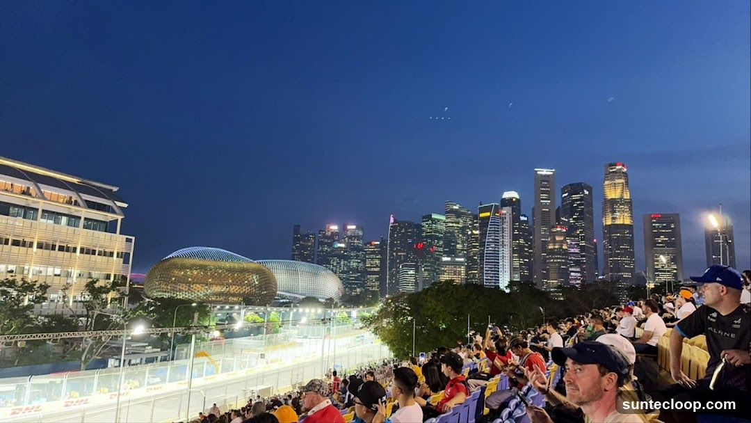 Nighttime cityscape with spectators at a race track