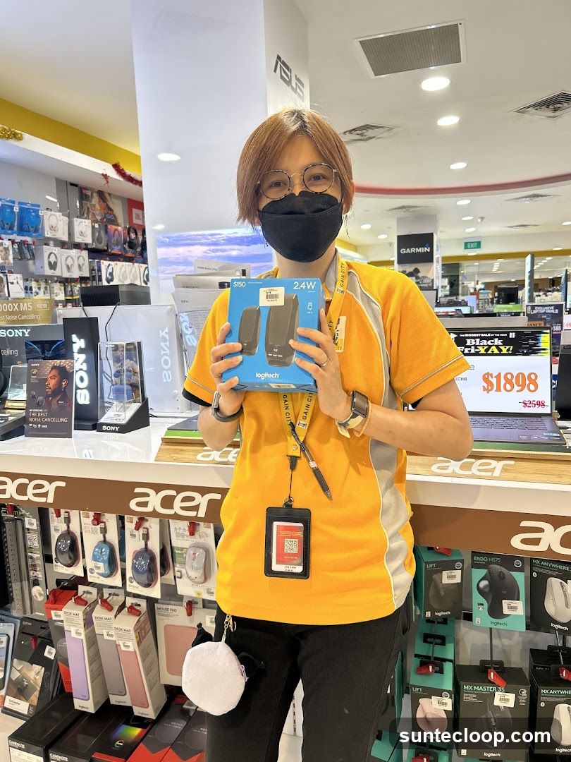 Store employee holding Logitech speakers