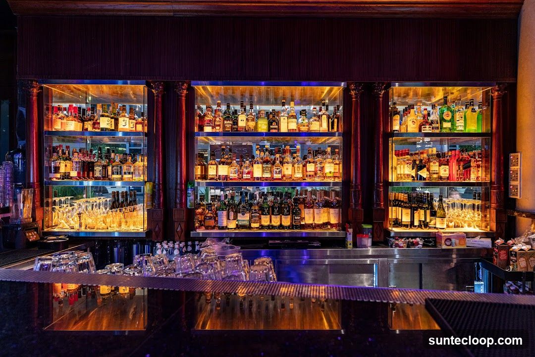 Bar with illuminated shelves of liquor bottles