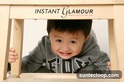 Young boy peeking through wooden frame with logo