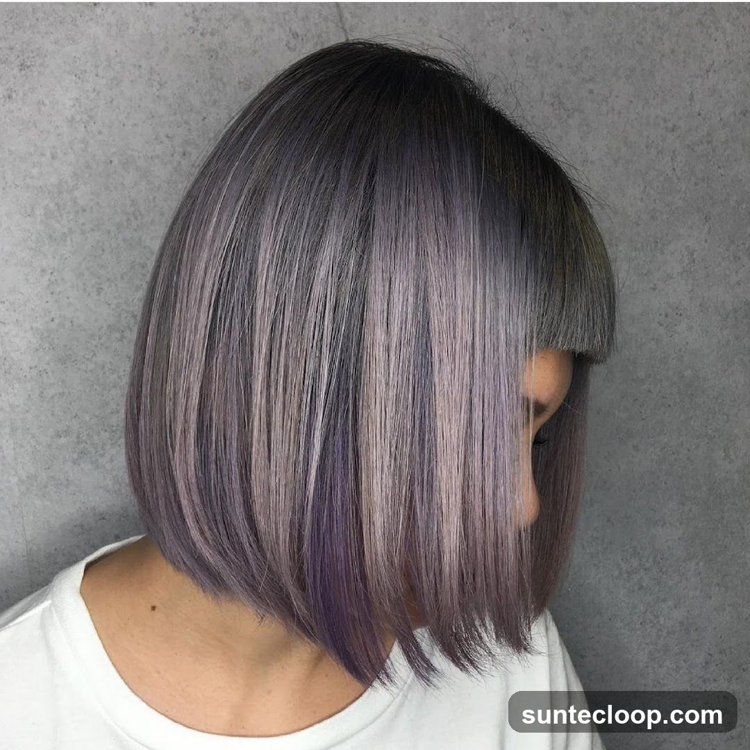 Woman with a bob haircut with purple and gray highlights