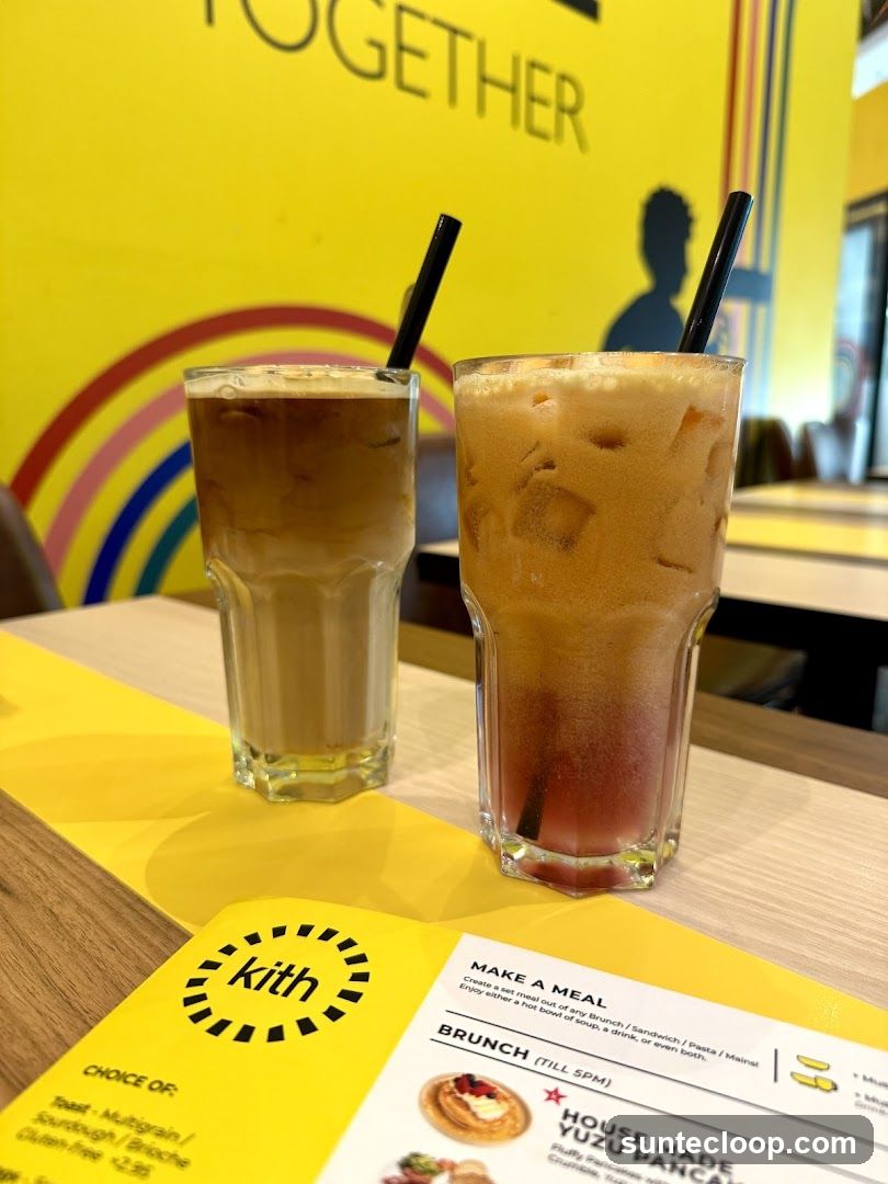 Two iced drinks on a table with a menu