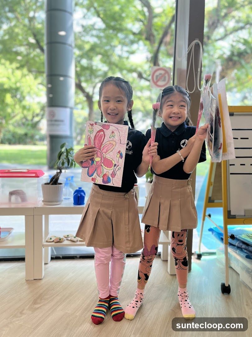 Two young girls holding artwork and art supplies