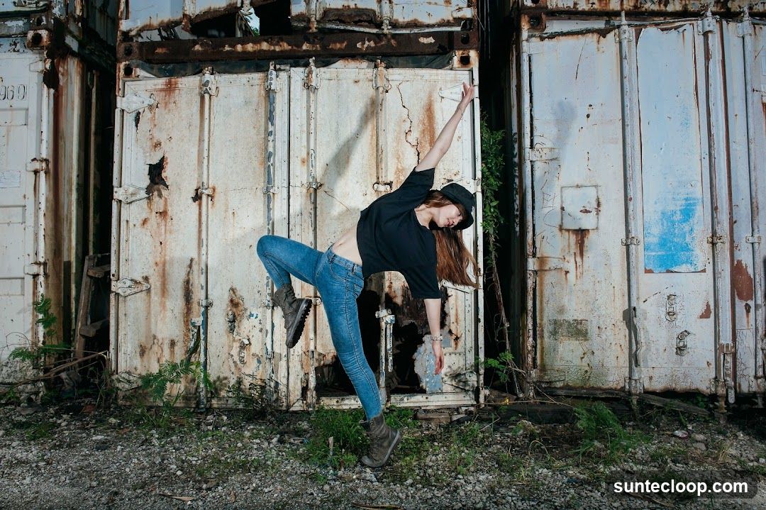 Dancer Poses Against Rusted Shipping Containers