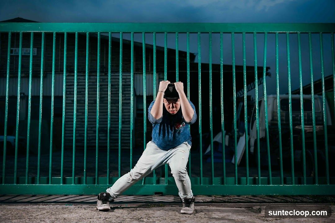 Person posing in front of a green gate