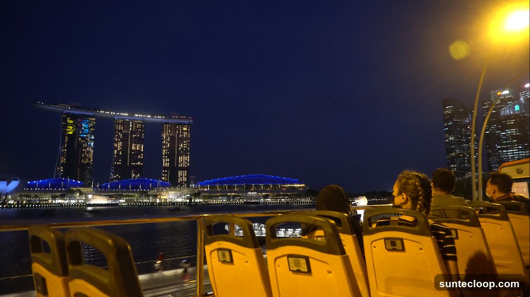 Night view of Marina Bay Sands and city skyline from a bus