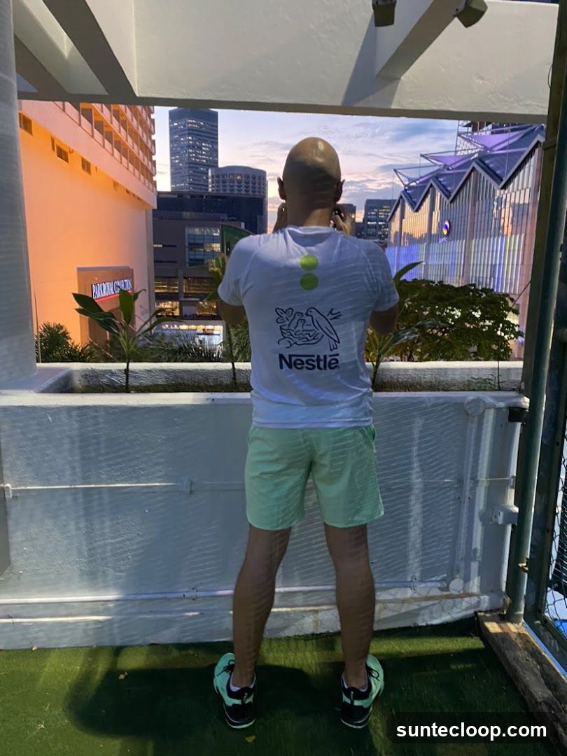 Man in Nestle T-shirt taking photo of cityscape
