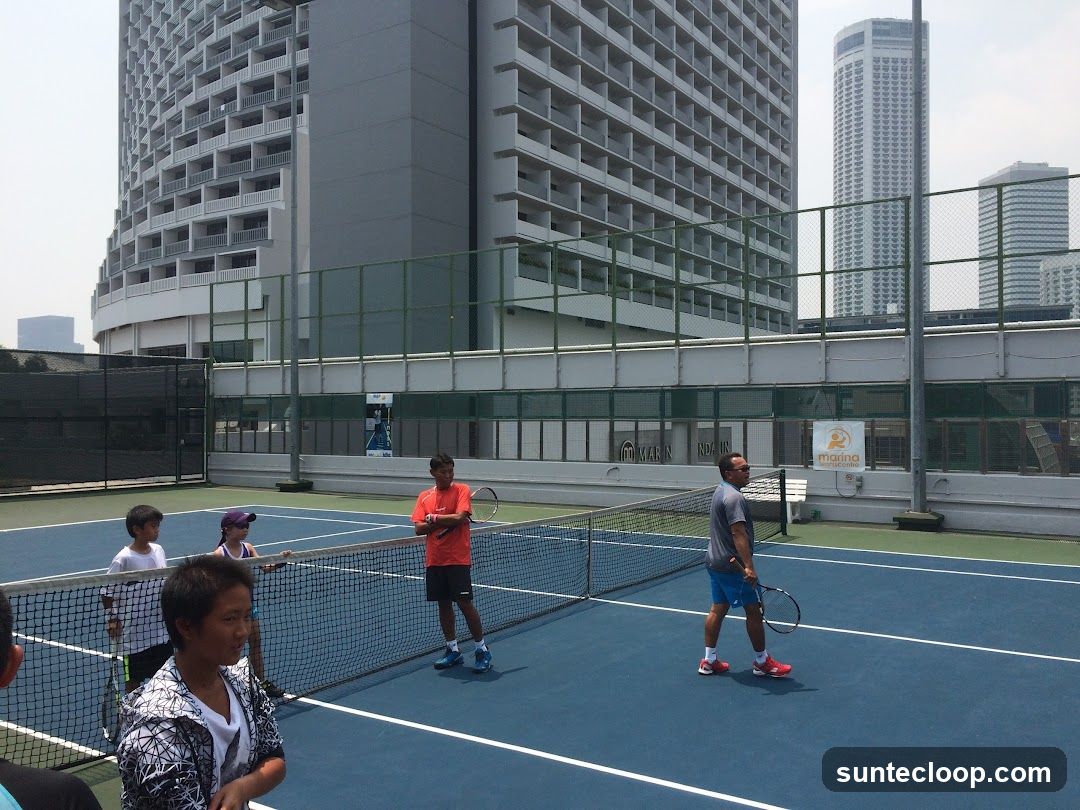 Tennis Court with Players and City Buildings