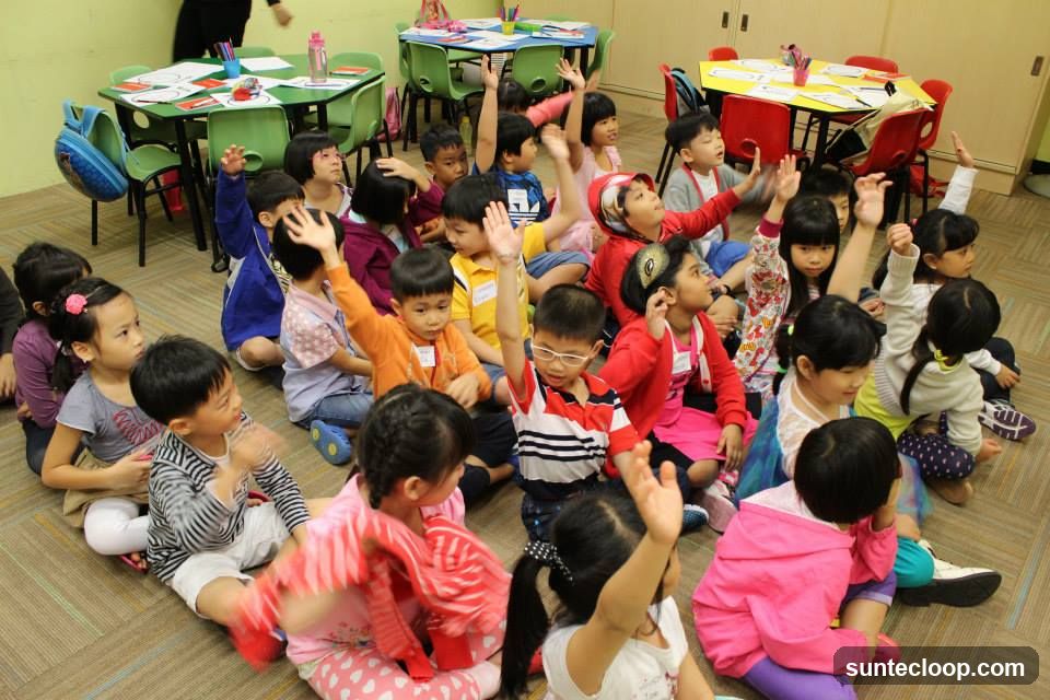Children in a classroom raising their hands