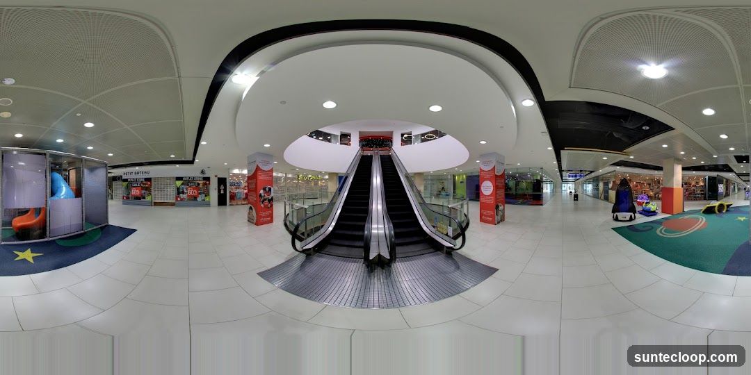 Shopping mall interior with escalators and play area