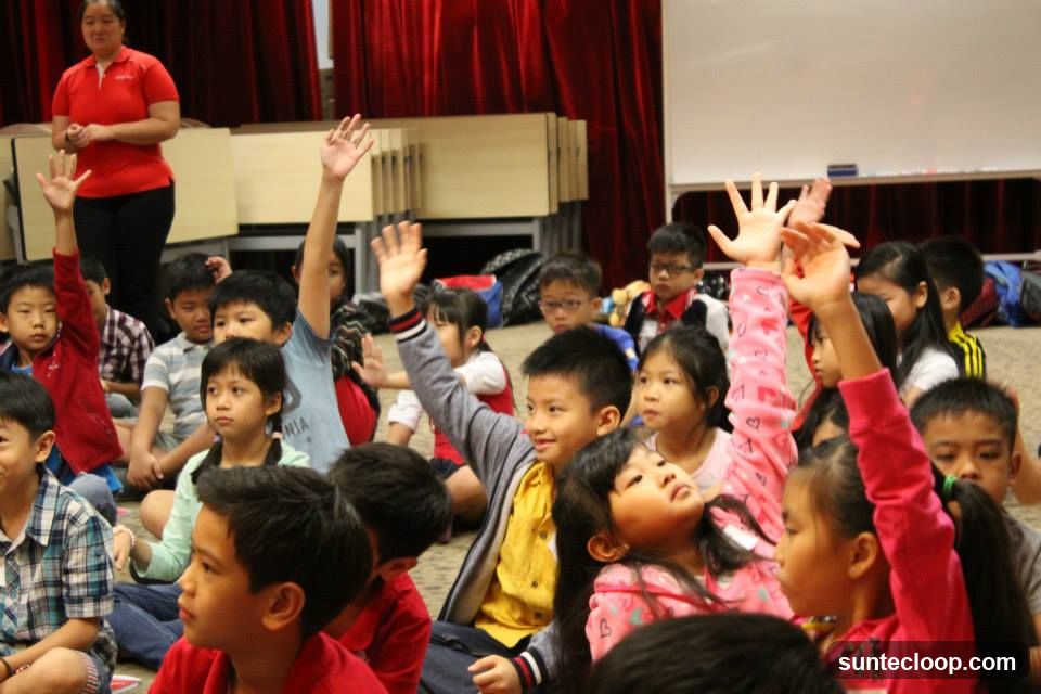 Children raising hands in a classroom