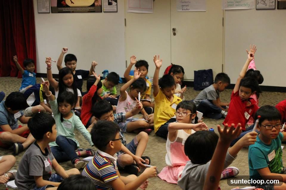 Children raising hands in a classroom