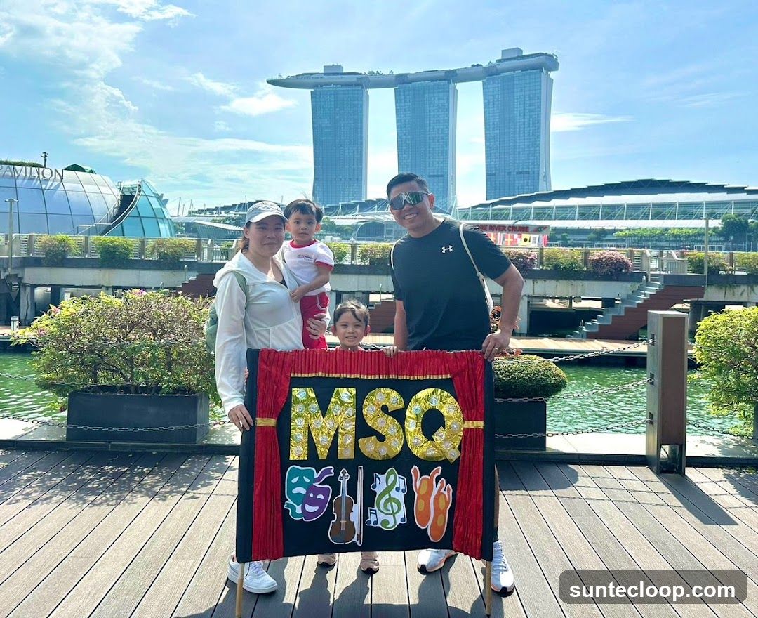 Family holding a sign with "MSOQ" and symbols