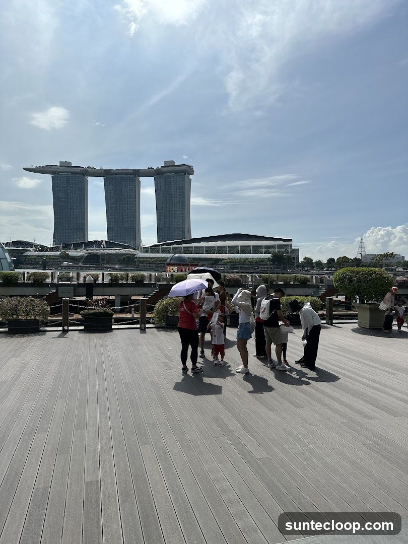 People on a boardwalk with Marina Bay Sands in the background