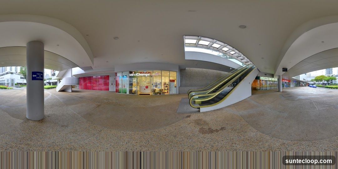 Shopping mall walkway with escalators and storefronts
