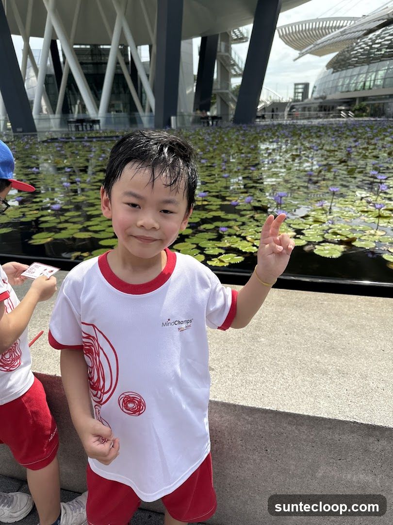 Boy in front of a pond with water lilies
