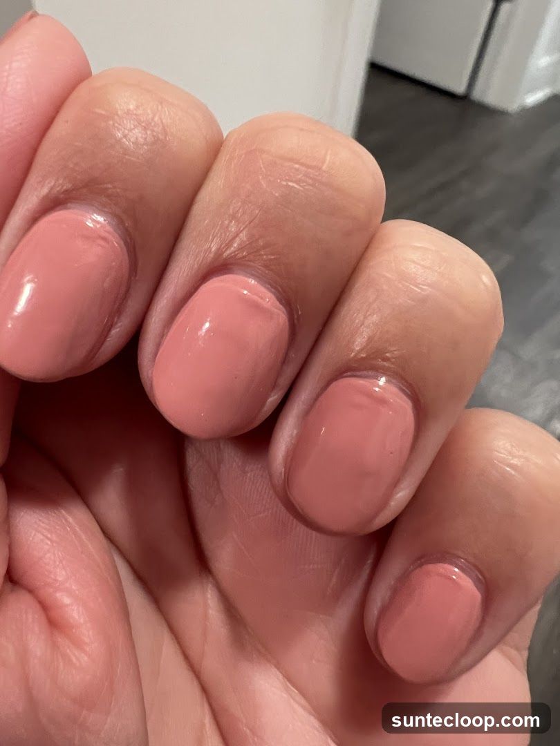 Close-up of a hand with coral-colored nail polish