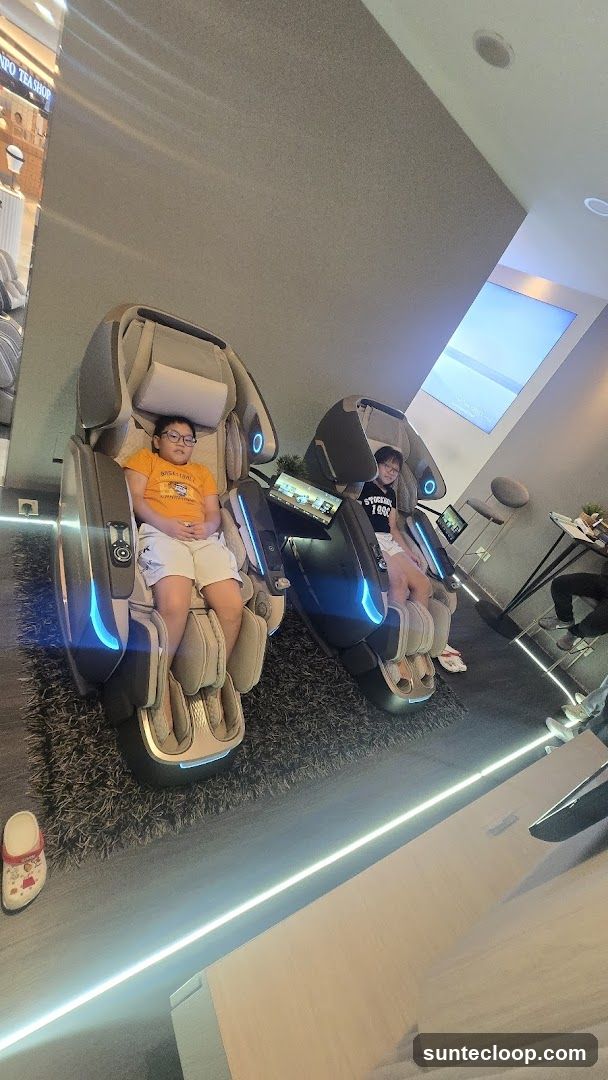 Two children relax in massage chairs