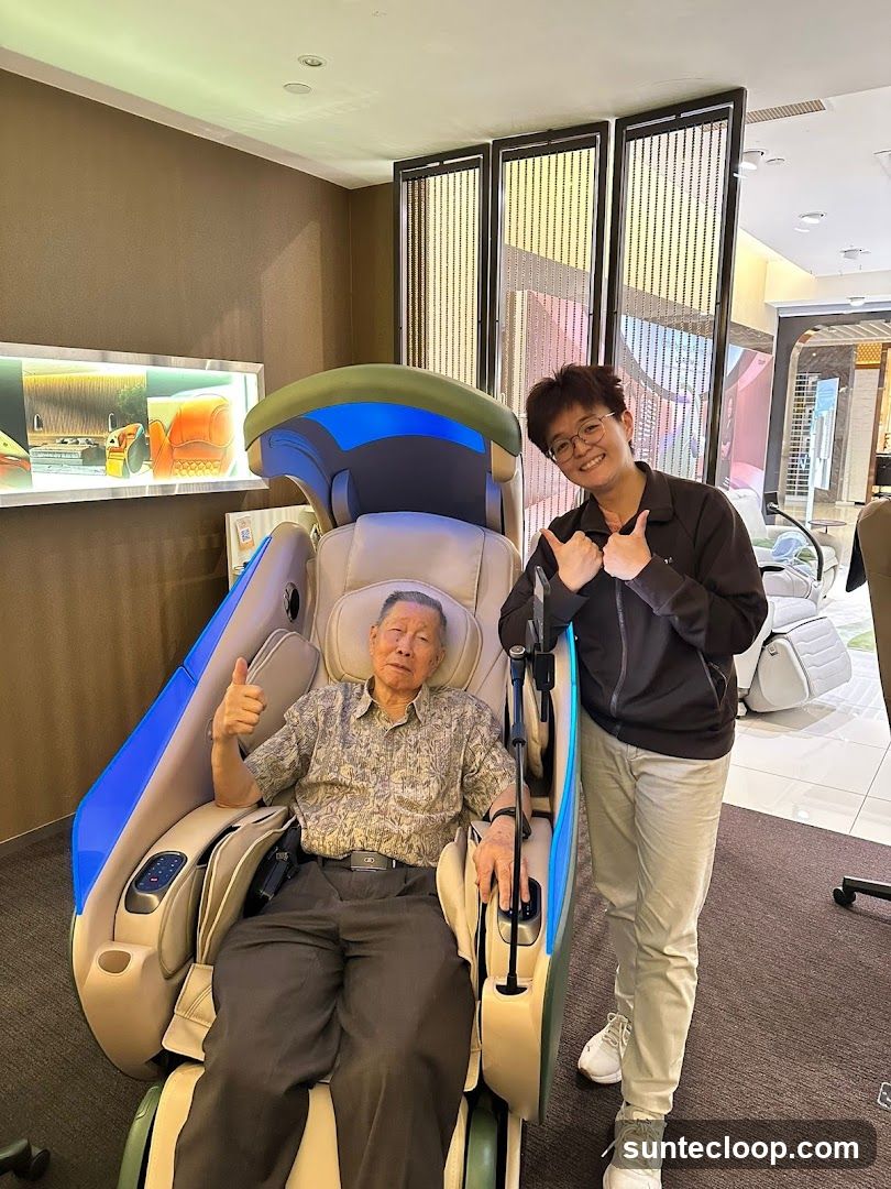Elderly Man and Young Person in Massage Chair