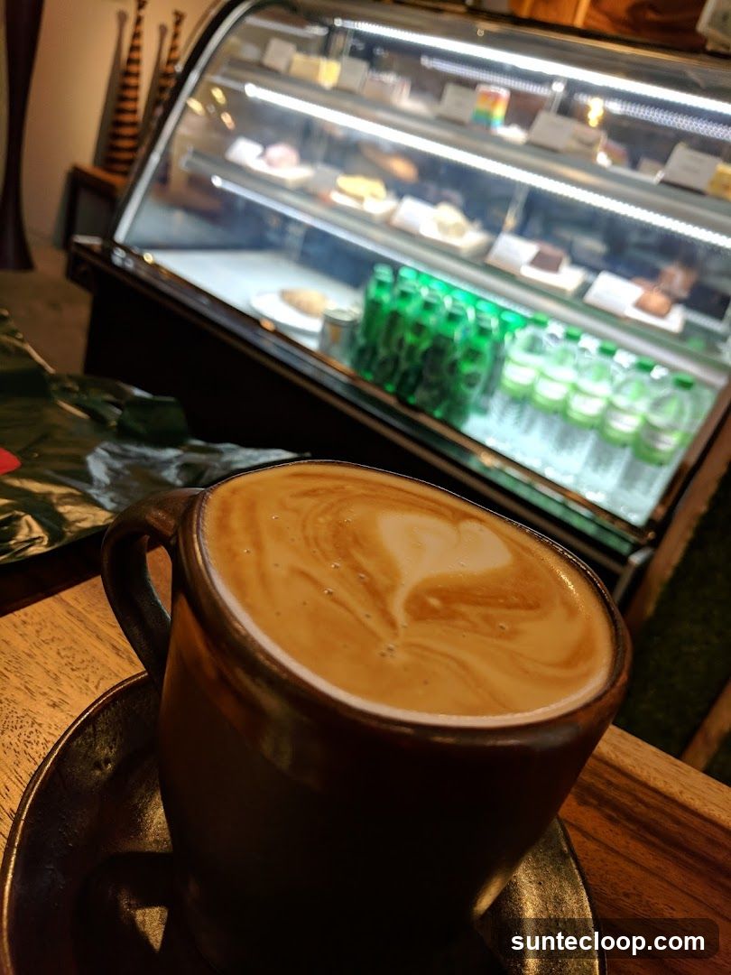 Latte with Heart Art and Pastries in Display Case