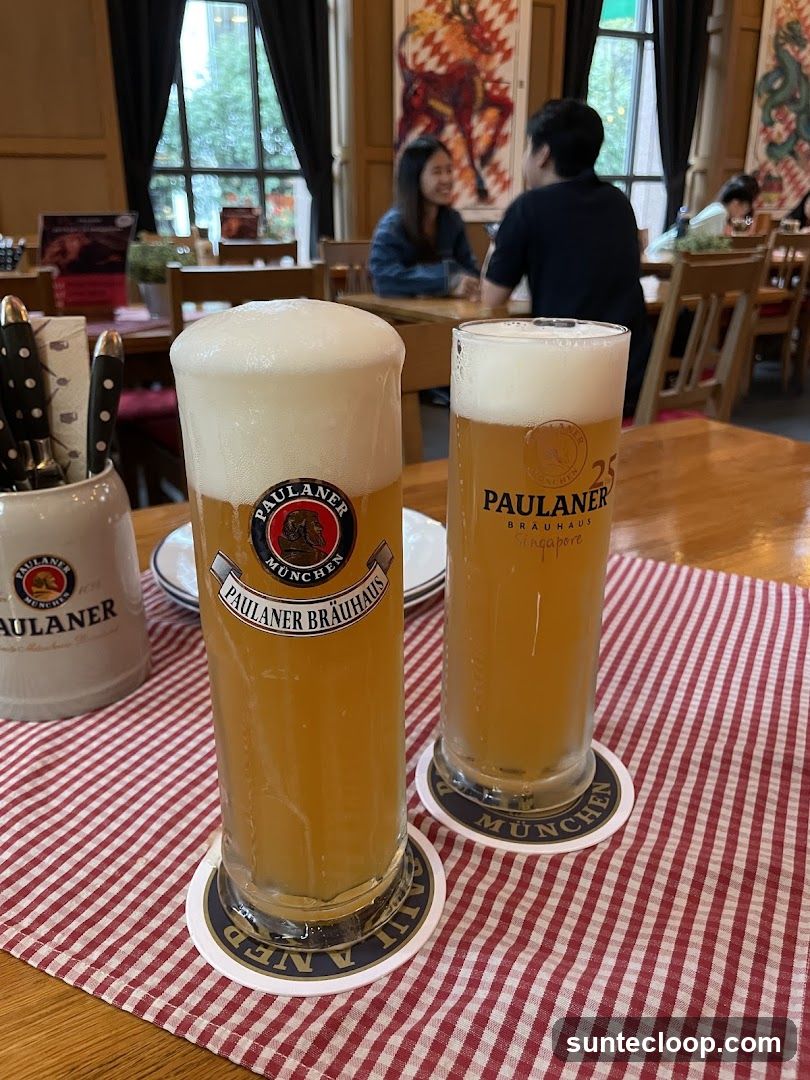 Two glasses of Paulaner beer on a table