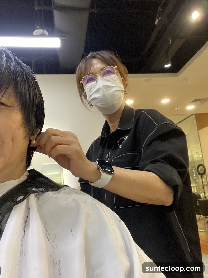 Hairdresser cutting client's hair