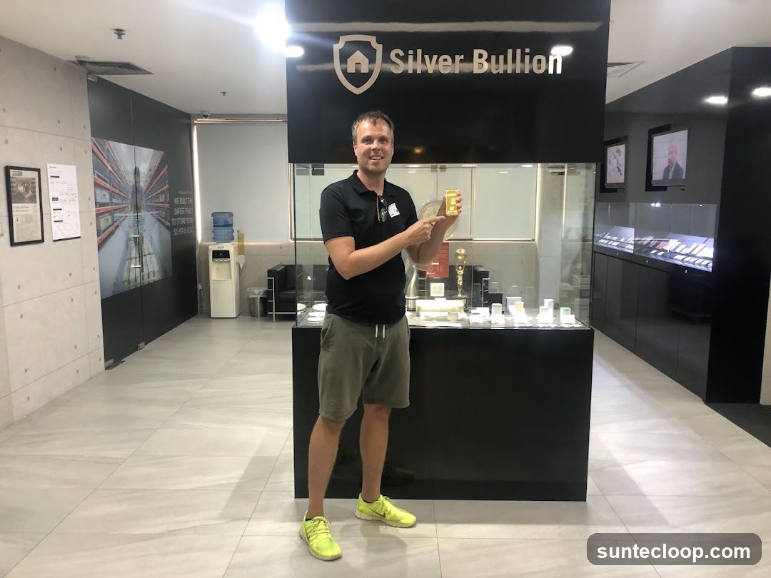 Man holding gold bar in bullion store