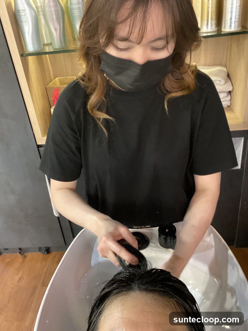Hairdresser washing client's hair
