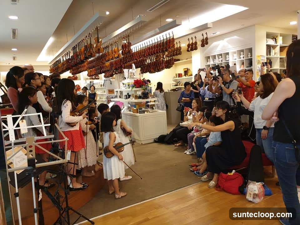 Children playing violins in a store