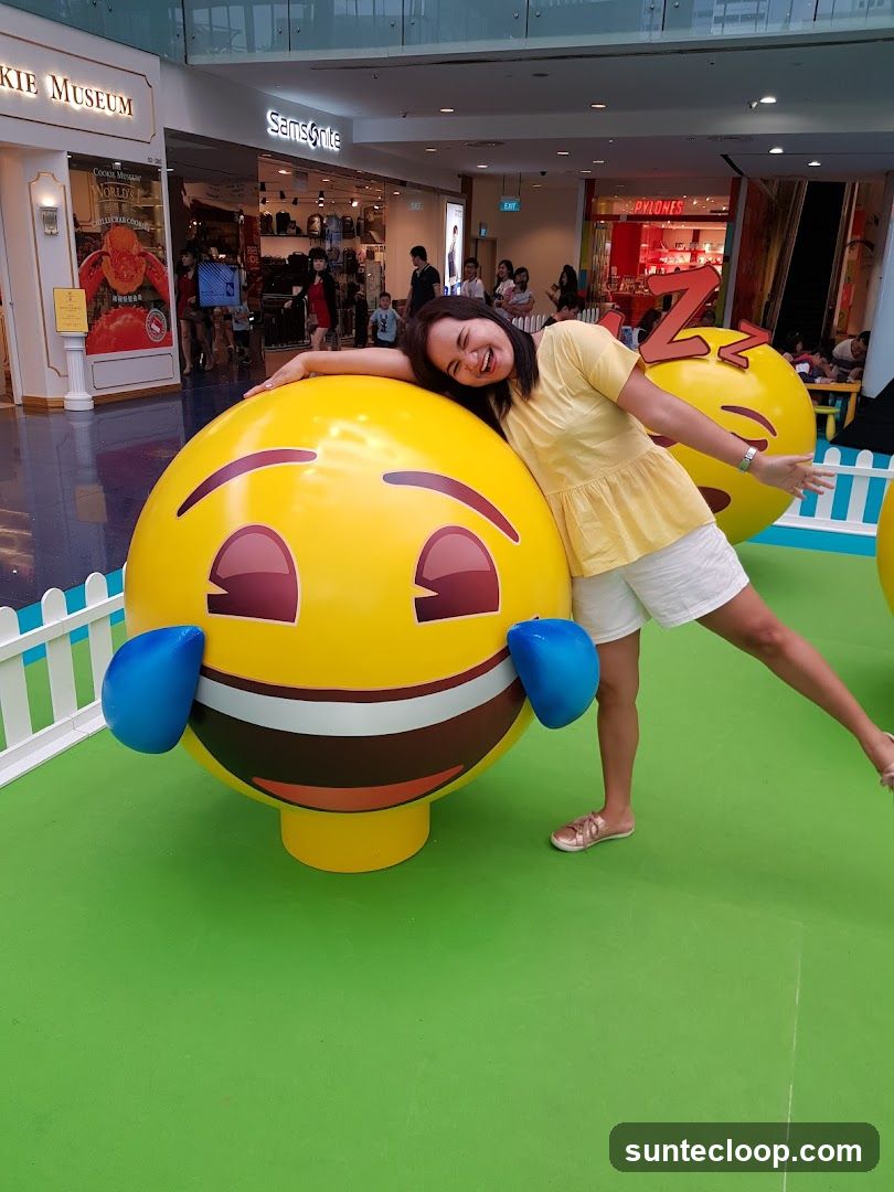 Woman posing with large emoji statue
