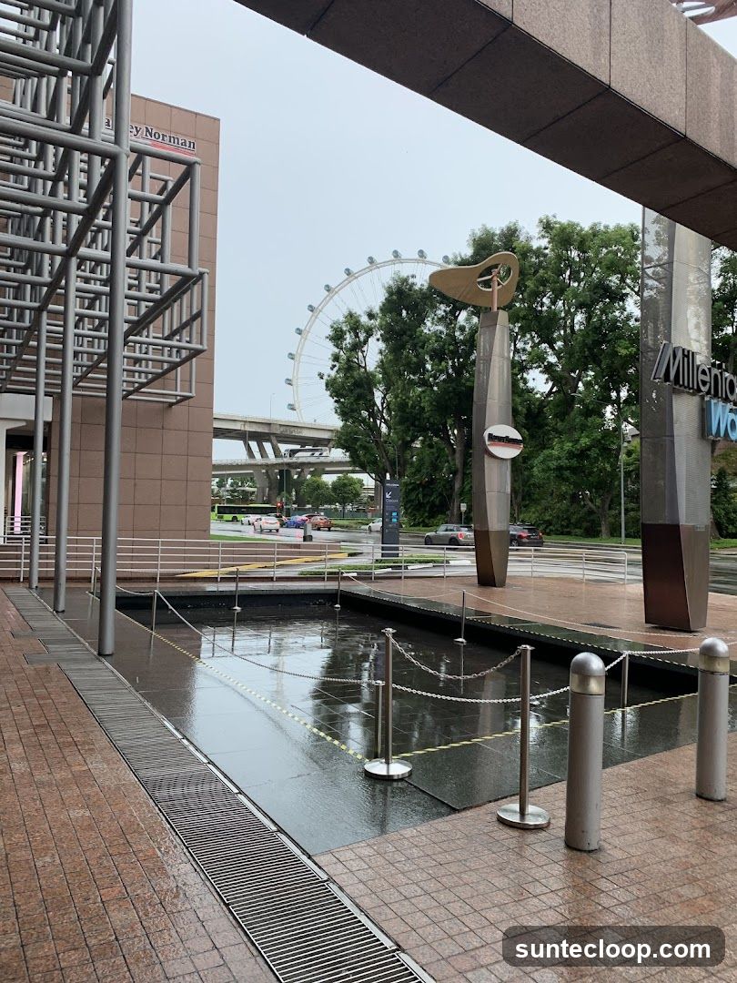 Outdoor plaza with a fountain and a Ferris wheel in the background