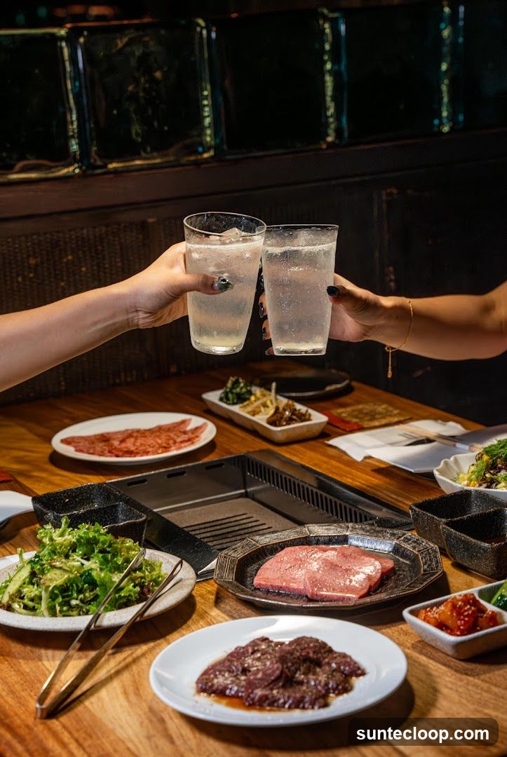 Friends toasting with drinks at a table with food