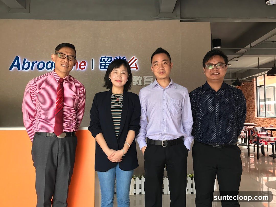 Four people standing in front of a company logo
