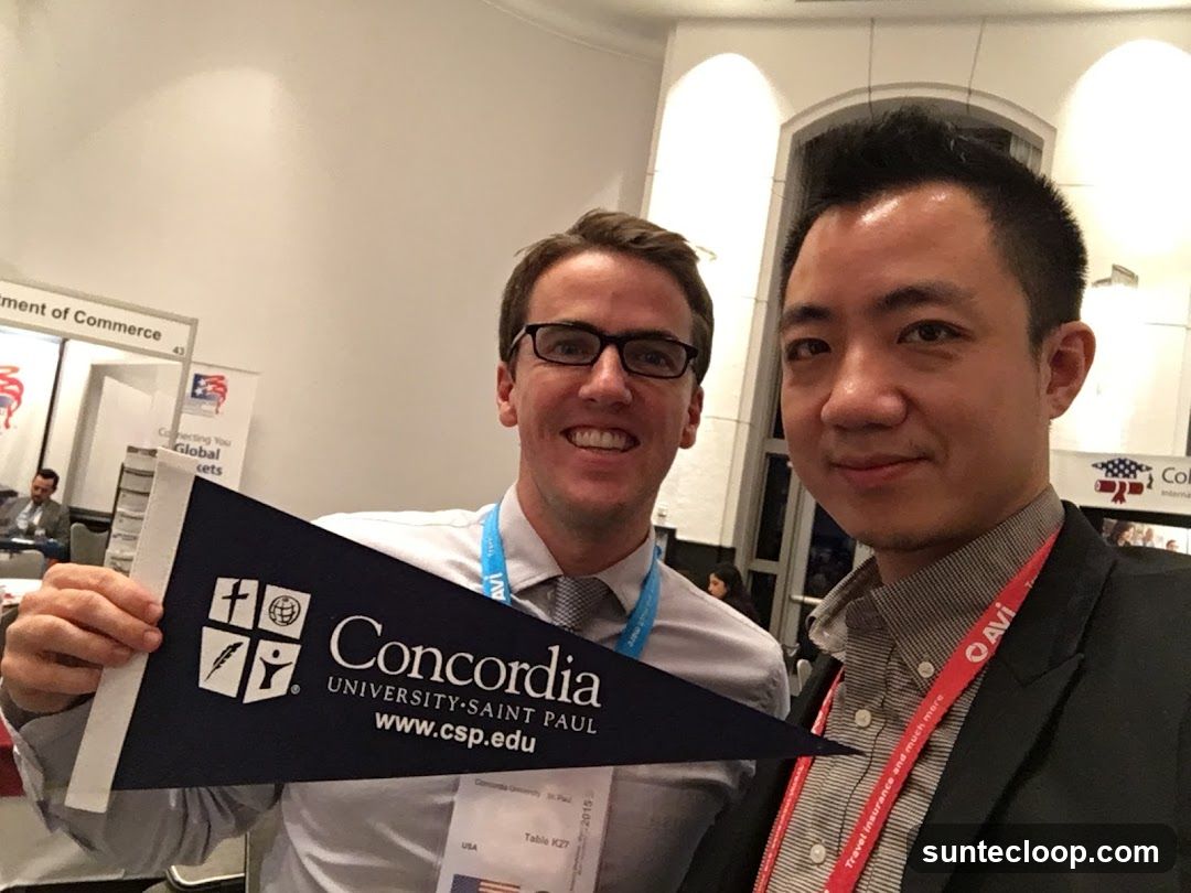 Two men holding a Concordia University-Saint Paul pennant