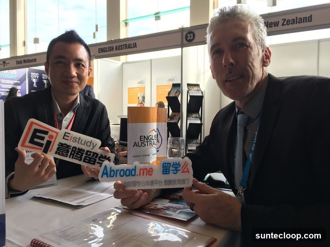 Two men holding signs at a booth