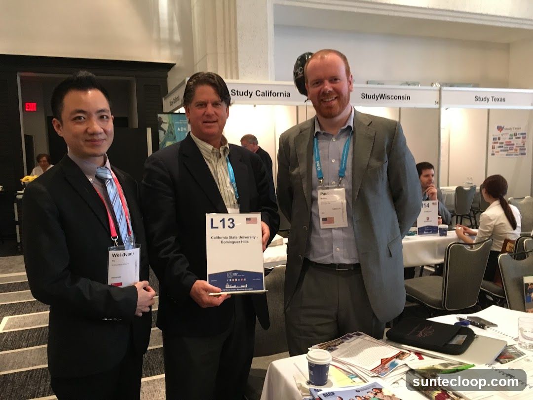 Three men at a conference booth